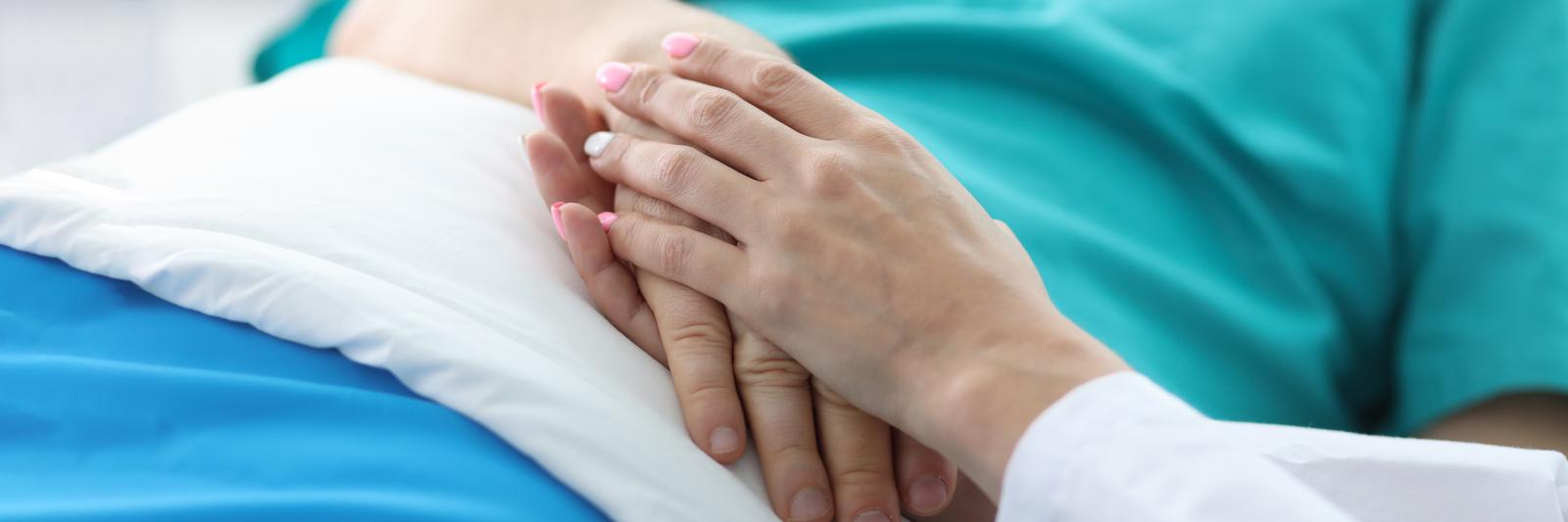 Nurse holding patient hand