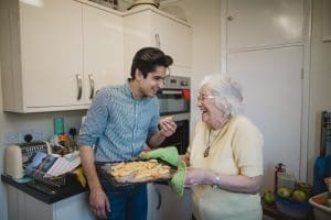 The struggle to prioritize during the Sandwich Generation. Elderly parent actively participating in family life, supporting their adult children and grandchildren in everyday routines.
