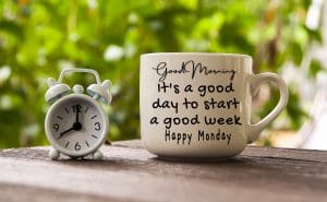 An alarm clock and a coffee mug with text saying- It is a good day to start a good week.