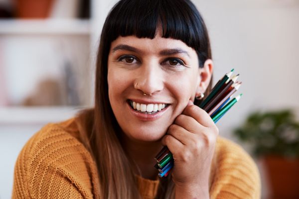 smiling artist with colored pencils