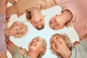 senior women in a circle helping each other to thrive as a sandwich generation caregiver