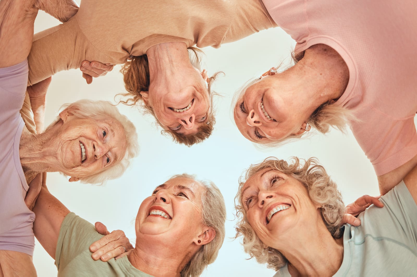 senior women in a circle helping each other to thrive as a sandwich generation caregiver