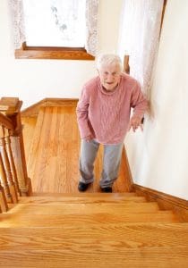 Senior woman in front of staircase.